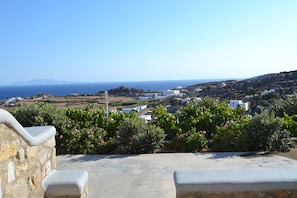 A coastal town with white buildings, a view of the sea, and lush greenery.