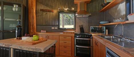 A kitchen with wooden cabinets, a built-in oven, a microwave, and a large window.