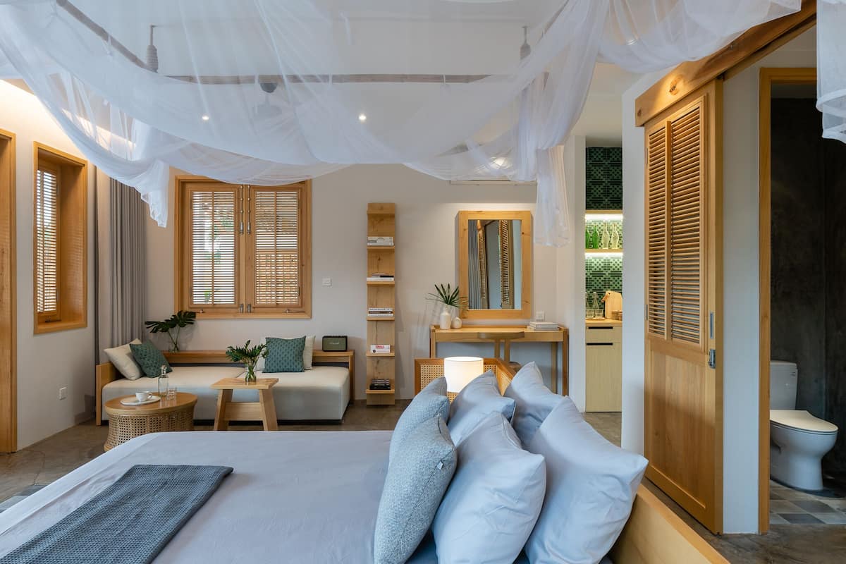 A bedroom with a large bed, bedside tables, a desk, and a wardrobe.