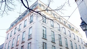 A multi-story building with a symmetrical facade, large windows, and a corner balcony. - Chiado 1 - Carmo Square - Recently renovated apartment with great view of the River Taugus and São J (Lisbon)
