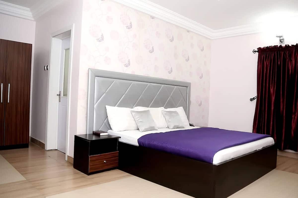 Une chambre à coucher comprenant un lit, une table de chevet, une armoire et une chaise.