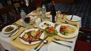 A dining table set with plates of food, cutlery, and beverages. - Hotel Ibis Royale Owerri (Owerri)