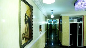 A hotel hallway with a long corridor, a large framed picture on the left, and a sign above a door on the right. - Hotel Ibis Royale Owerri (Owerri)