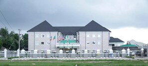 Een gebouw met twee verdiepingen, met een bord waarop 'HOTEL IBIS ROYALE' staat.