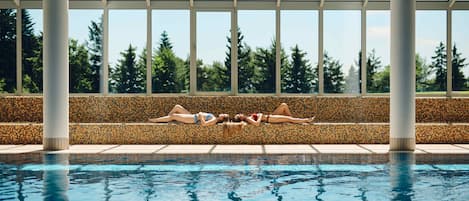 Una piscina techada, sillones reclinables de piscina