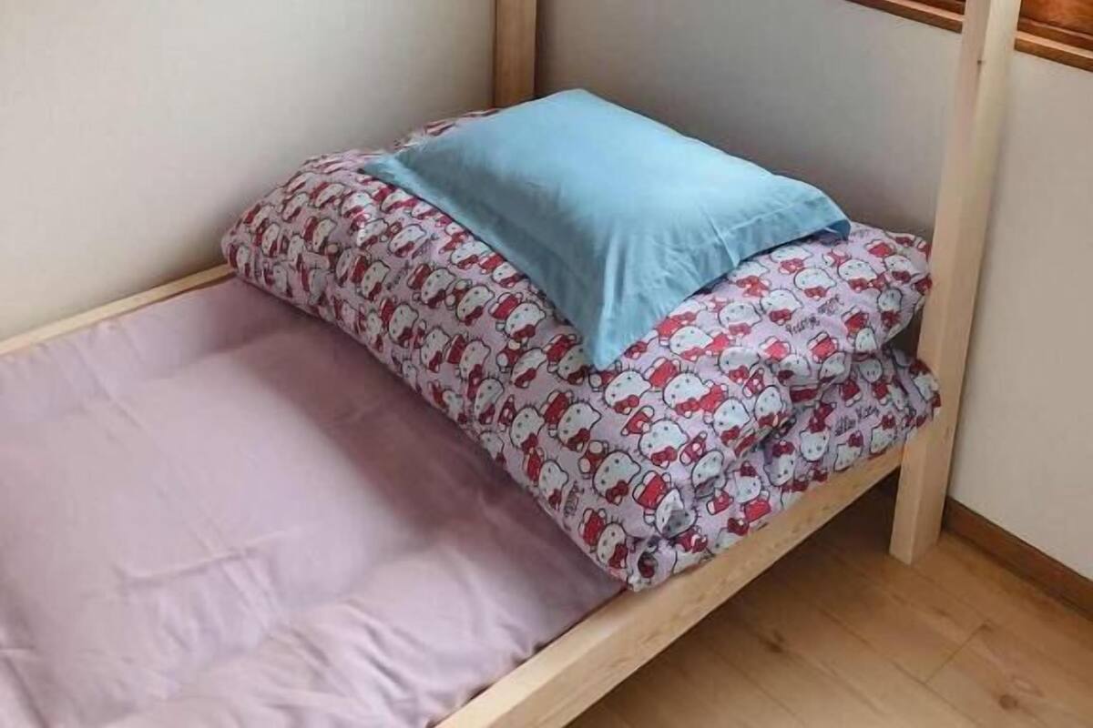 A bunk bed with two levels, each with patterned bedding and pillows.