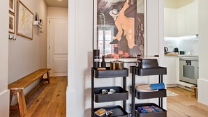 A modern kitchen with white cabinets, a built-in oven, and a countertop with a coffee machine.