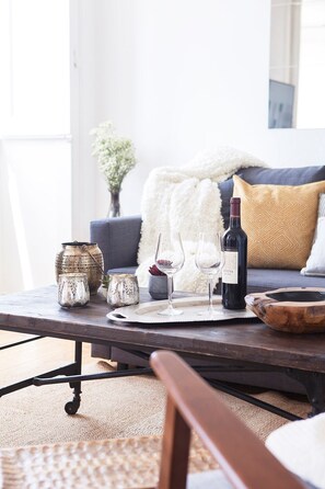 Una mesa de comedor con una botella de vino, dos copas y objetos decorativos.