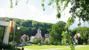 A park with a church, a flag, and traditional houses. - Ulrike's Pension am Kurpark (Bad Sooden-Allendorf)