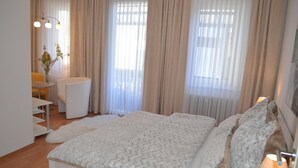 A bedroom with a bed, a bedside table, a lamp, and a chair. - Ulrike's Pension am Kurpark (Bad Sooden-Allendorf)