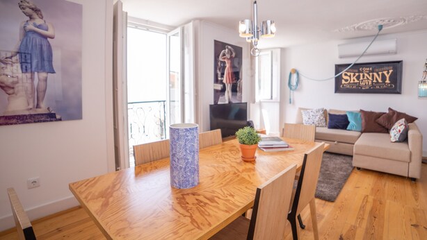 Un salon moderne avec une table à manger en bois, une plante en pot et un canapé.