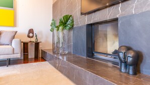 A modern living room with a fireplace, a sofa, a coffee table, and decorative vases.