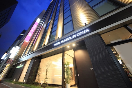 A hotel with a modern facade, large windows, and a sign reading "HOTEL SUNROUTE GINZA".