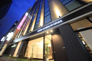 Un hotel con fachada moderna, amplias ventanas y un letrero que dice "HOTEL SUNROUTE GINZA".