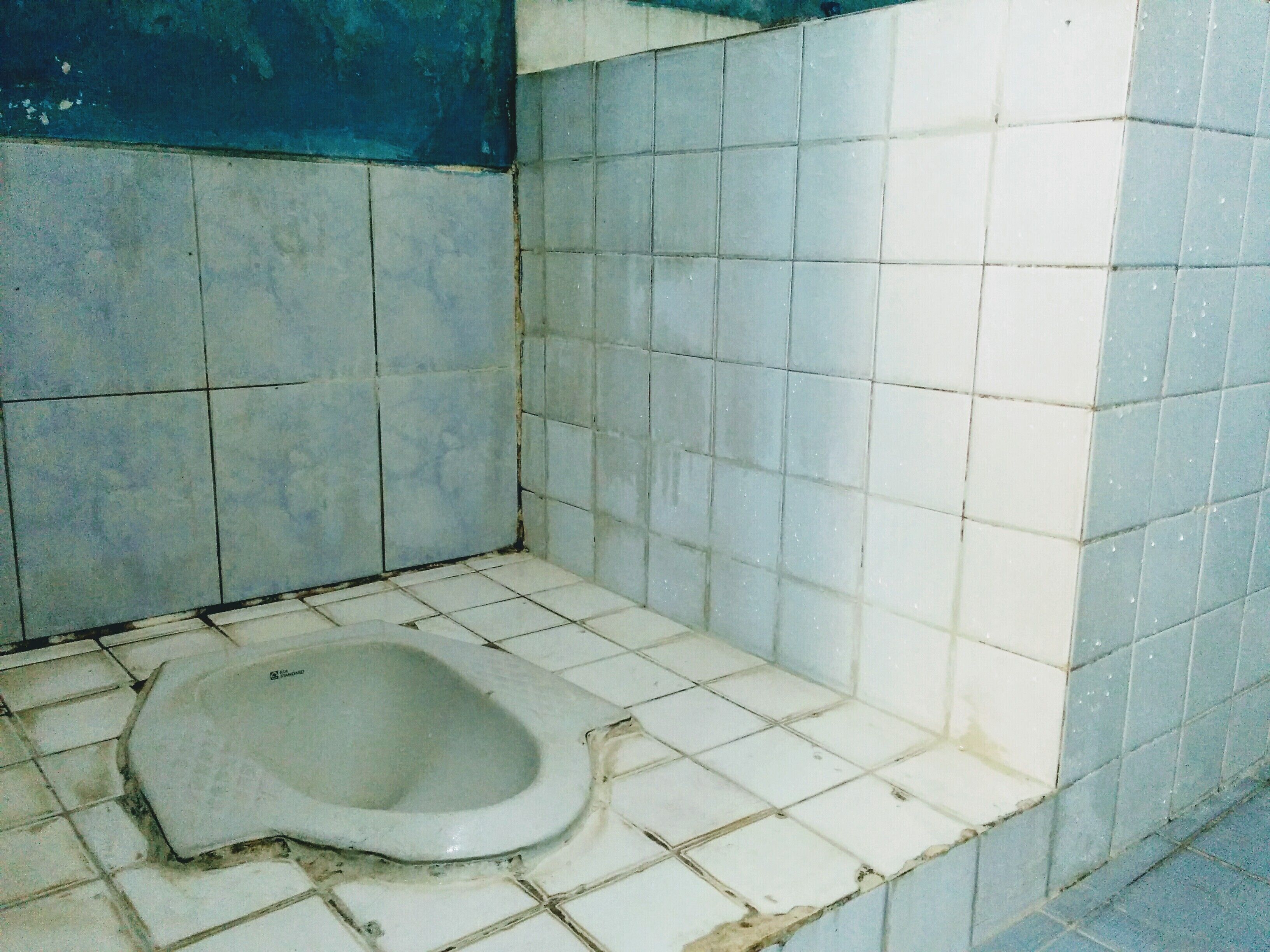 A small, tiled bathroom with a single toilet.