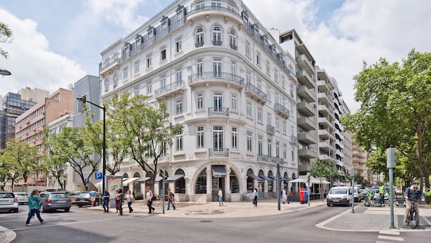 Un immeuble à plusieurs étages, de style architectural classique, doté de balcons et de grandes fenêtres.