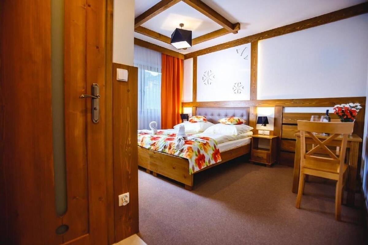 A bedroom with a wooden bed, a desk, and a chair.