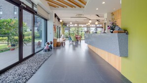 Een moderne receptie met een houten plafond, grote ramen en een receptiebalie.