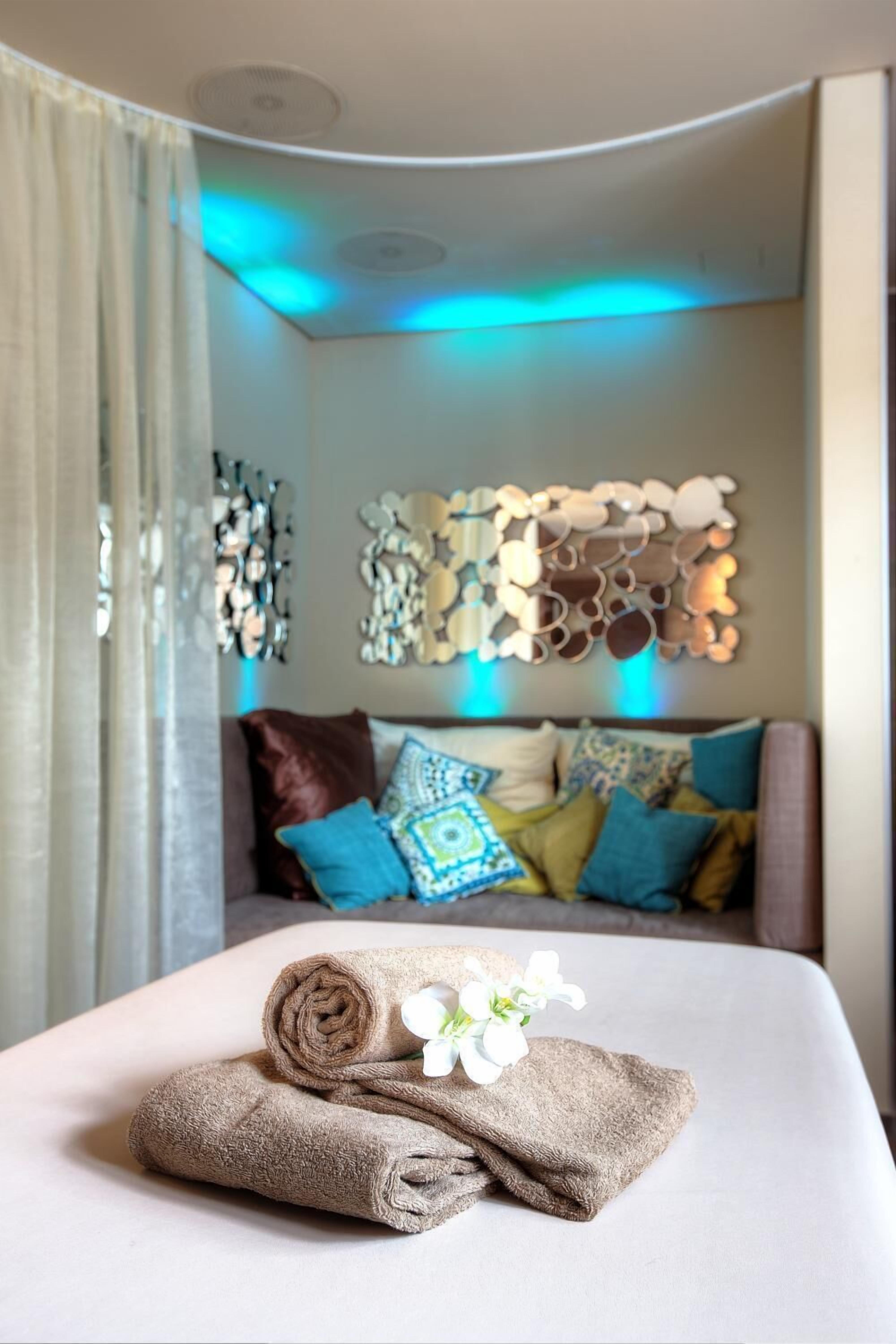 Una habitación de hotel con una cama bien hecha, un adorno en la pared y una ventana con cortinas.