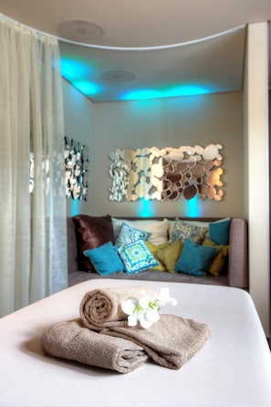 A hotel room with a neatly made bed, a decorative wall piece, and a window with curtains. - Land  & Golf Hotel Stromberg (Stromberg)