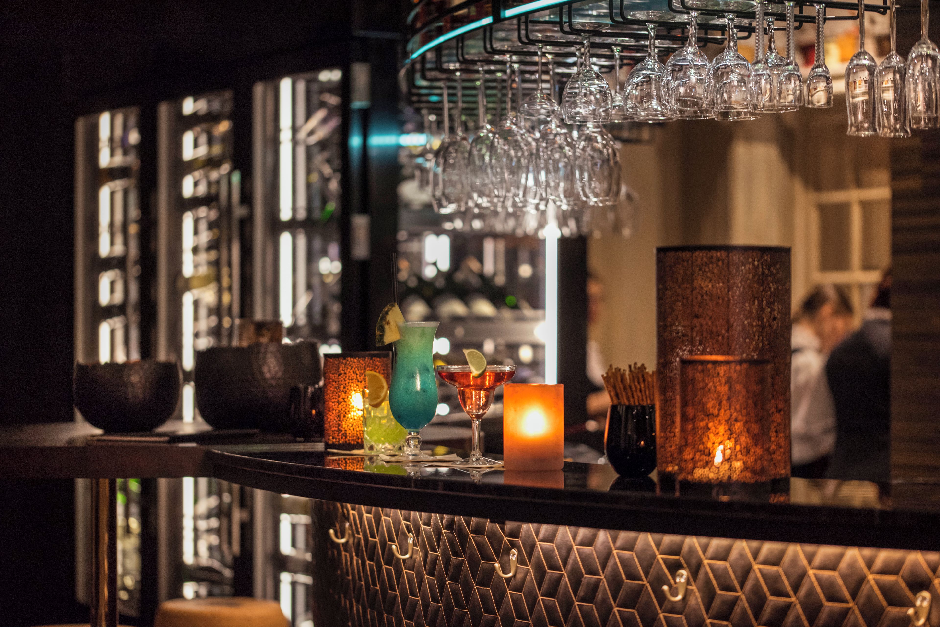 Un espace bar doté d’une variété de verres, notamment des verres à vin et des verres à cocktail, disposés sur un présentoir.