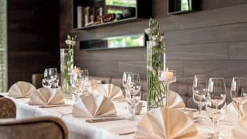 A table set for a formal dining occasion with clear glassware, folded napkins, and a candle centerpiece.