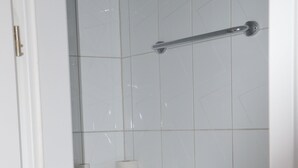Ein Badezimmer mit Toilette, Handtuchhalter und Papierhandtuchspender.