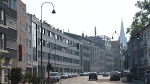 Ein mehrstöckiges Hotel mit moderner Fassade an einer belebten Stadtstraße.