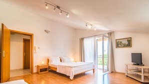 A bedroom with a bed, bedside table, TV, and a sliding glass door to a balcony. - Beautiful one bedroom apartment in Porec (Vrvari)