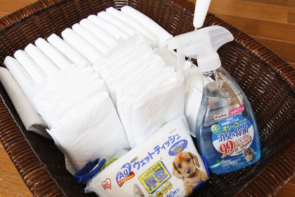 A basket containing folded white towels, a spray bottle, and a package of Ag brand cleaning wipes. - Amis Droles LIBERTY RESORT (Kawazu)