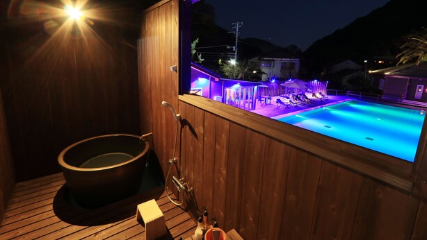Un espacio tipo spa de madera con jacuzzi y piscina.