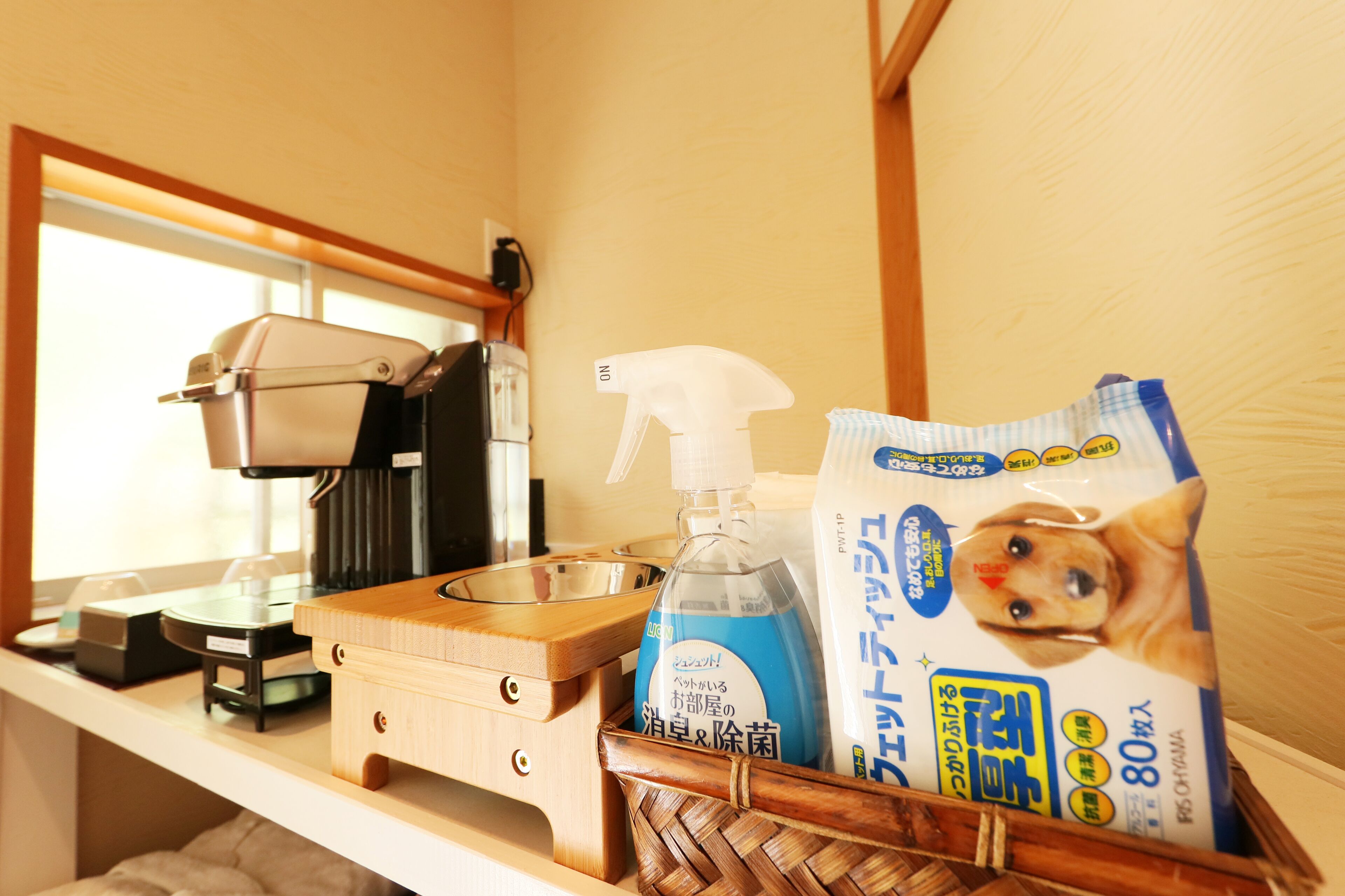 A kitchen counter with a coffee maker, a spray bottle, and a bag of pet food.