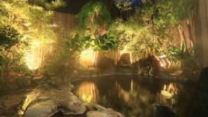Un jardín tranquilo con un estanque, bambú y rocas.