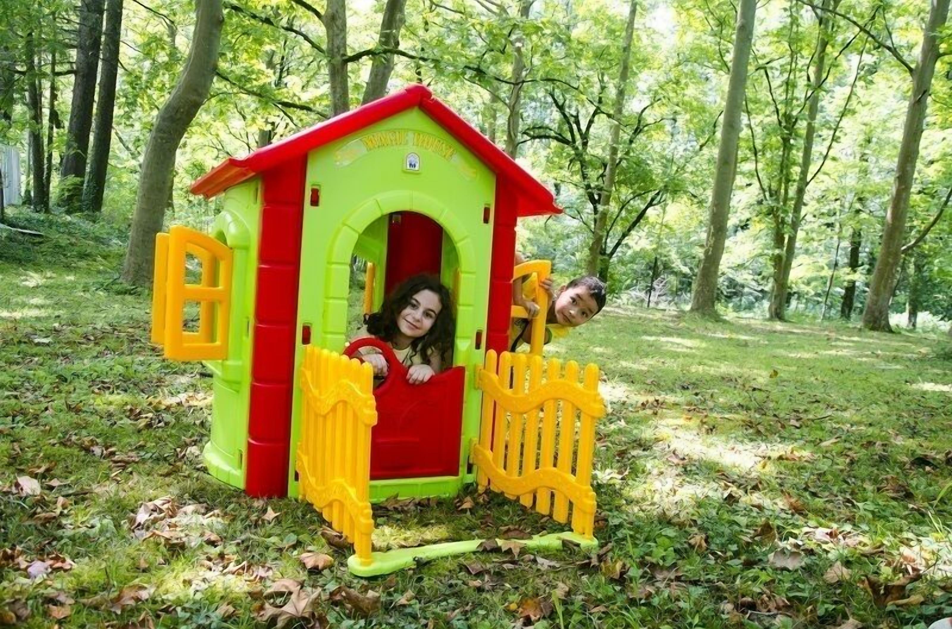 Une petite maison de jeu colorée, située dans un espace boisé.