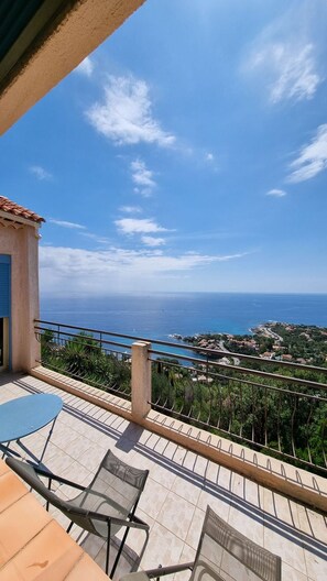 A terrace with a view of the sea, outdoor furniture, and a tiled floor. - Courrier sud  1918 - Four Bedroom Villa, Sleeps 8 (Les Issambres)