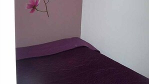A room with a purple mattress, a wall with a pink floral mural, and a white door. - La Calanque 263 villa (Les Issambres)