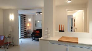 Una sala moderna con un sofá, una mesa de centro y un comedor con encimera de madera.