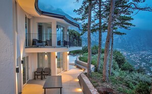 A modern house with a balcony overlooking a mountainous landscape.