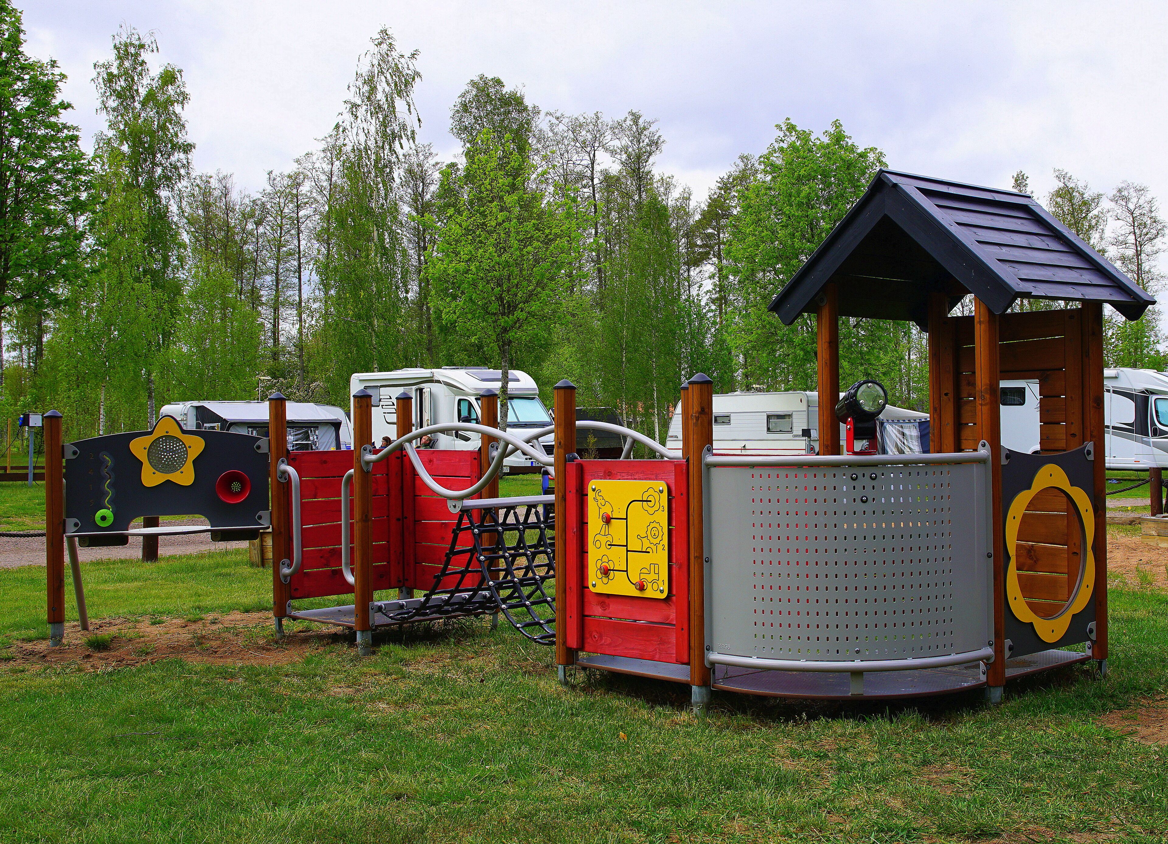 A playground with a climbing structure, a slide, and a small shelter.