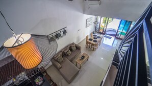 A spacious living area with a sofa, coffee table, and a dining table. - Villa Cantik (Legian)