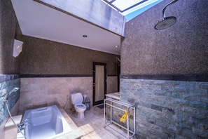 A bathroom with a bathtub, toilet, and shower. - Villa Cantik (Legian)