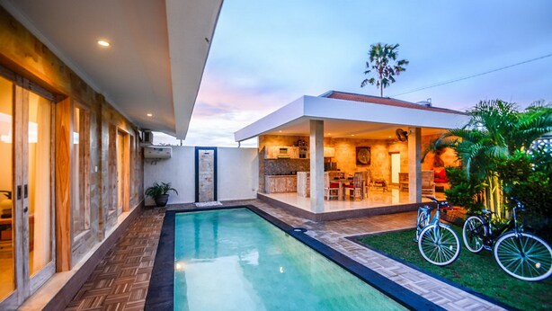 A modern house with a swimming pool, a covered patio, and bicycles. - Villa Airin (Canggu)