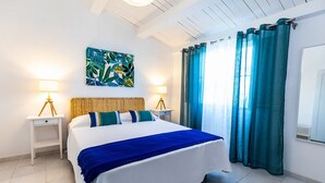 Une chambre à coucher moderne avec un grand lit, deux tables de chevet avec des lampes, une tête de lit et un tableau au mur.