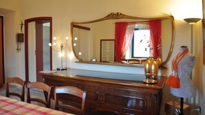 A room with a large mirror, a vanity with a red curtain, and a mannequin. - Chantale's posada (Giovinazzo)