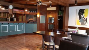 A restaurant with wooden interiors, a bar area, and a large abstract painting on the wall. - Hotel Gaya (Bad Soden am Taunus)