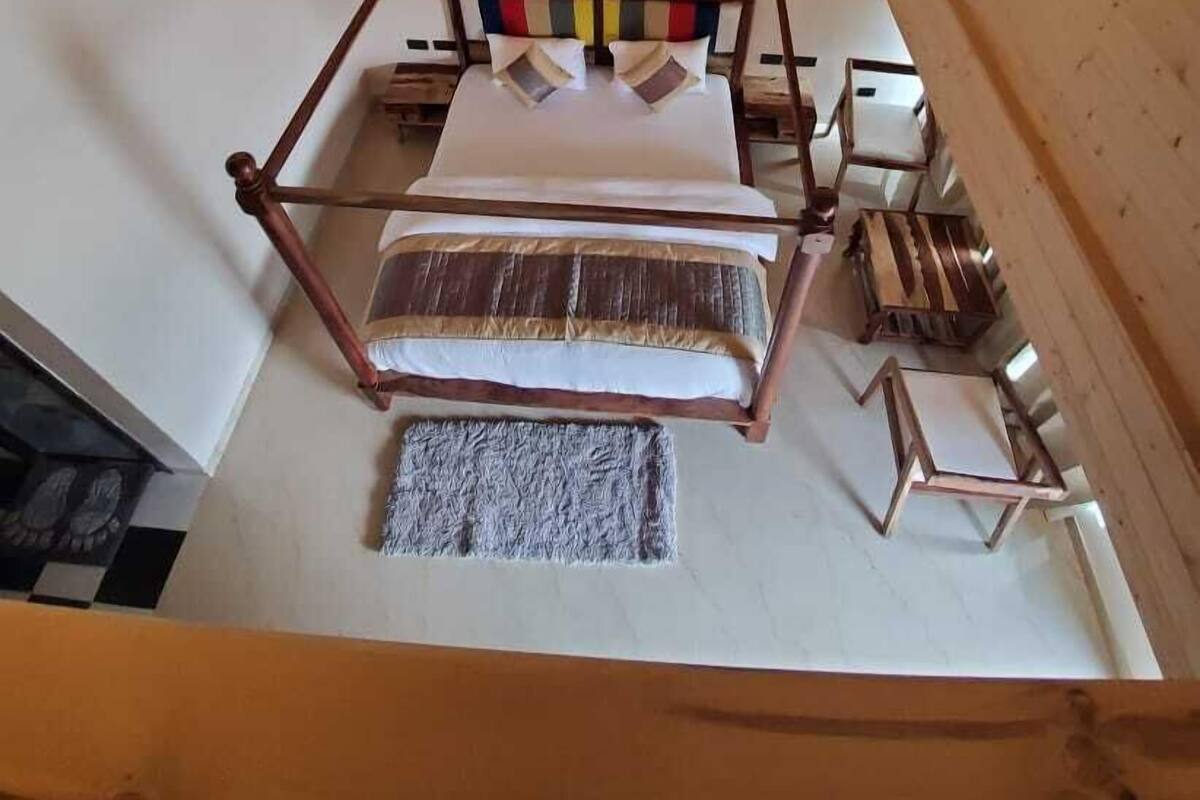 Ein Zimmer mit einem Bett, einem Deckenventilator und einem Holzkopfteil.