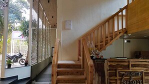 A wooden staircase leading to a reception desk labeled "Hill Hotel & Resort." - Seven Hills Hotels and Resorts (Lansdowne)