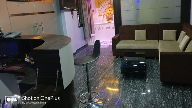 Una sala moderna con un sofá, una mesa de centro y una zona de bar con televisor.