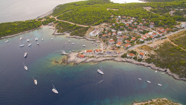 An aerial view of a coastal village with houses, boats, and a clear view of the sea. - Victorious VIScovery Red (Vis)