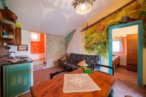 A cozy living room with a wooden table, a patterned sofa, and a colorful fish mural on the wall.